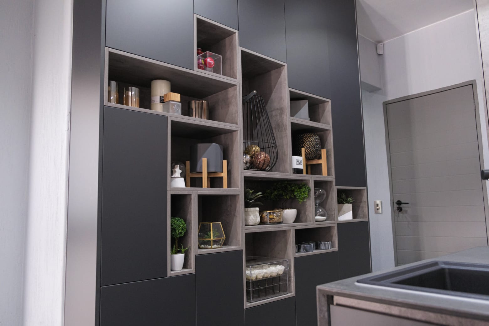 Sculptural custom storage niches in a Pandors Designs kitchen, styled with decor and display pieces