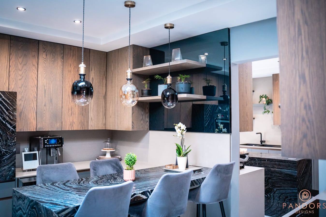 Pandors Designs kitchen finished in warm oak cabinetry with a dark glass splashback and open display shelving