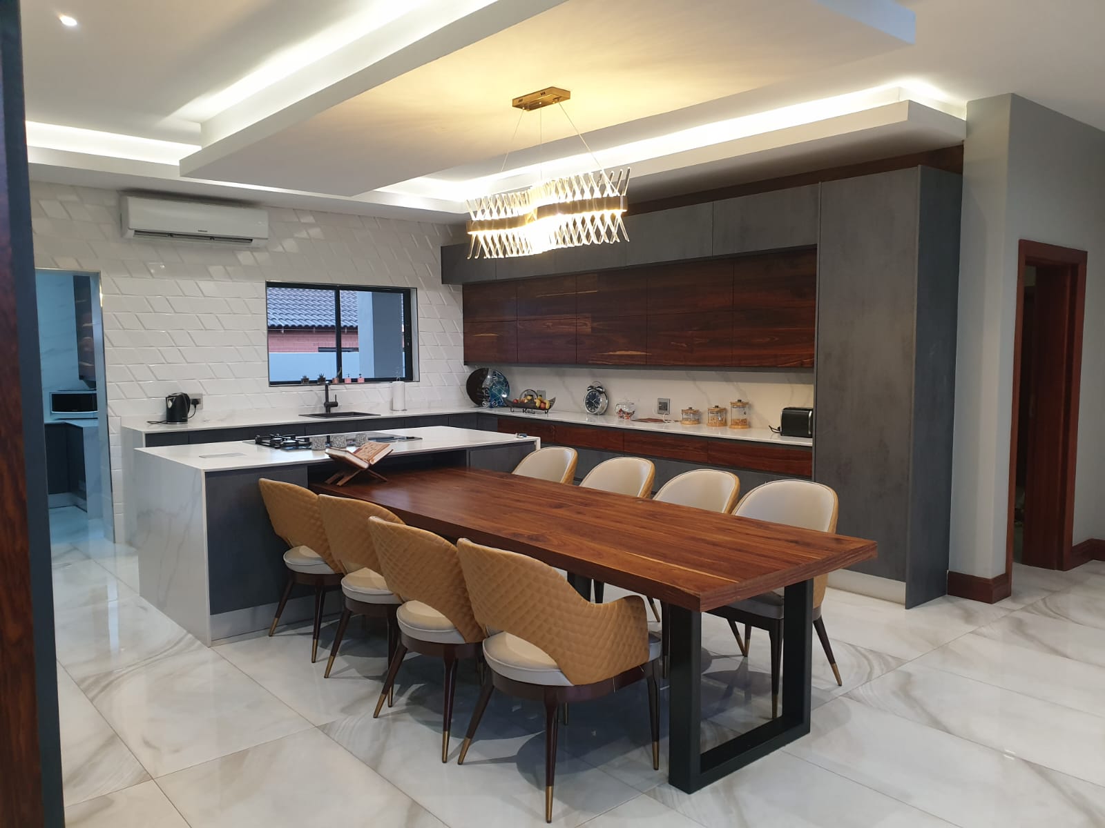 Open-plan Pandors Designs kitchen with rosewood-finish cabinetry and a live-edge walnut dining table