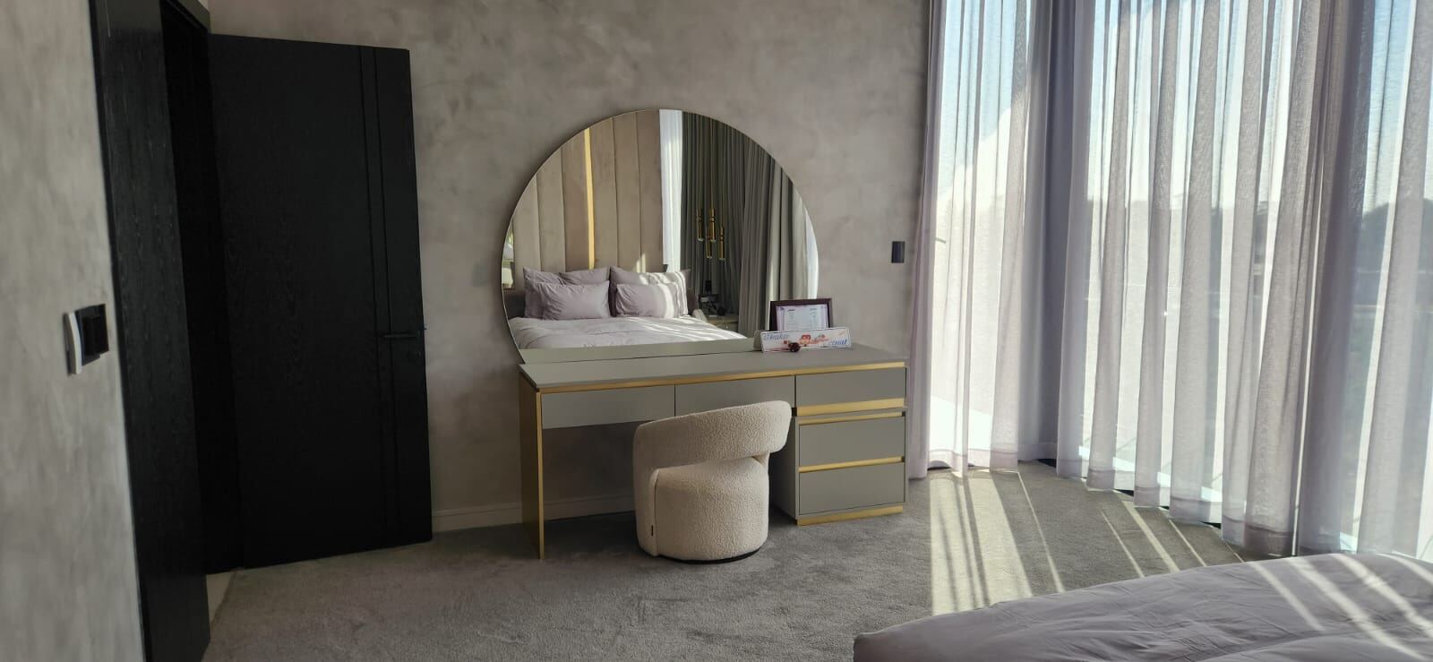 Pandors Designs bedroom dressing table with a round brass-trimmed mirror and boucle stool